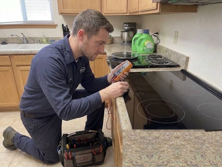 Cascadia technician running diagnostics on a glass cooktop at a Bellingham home